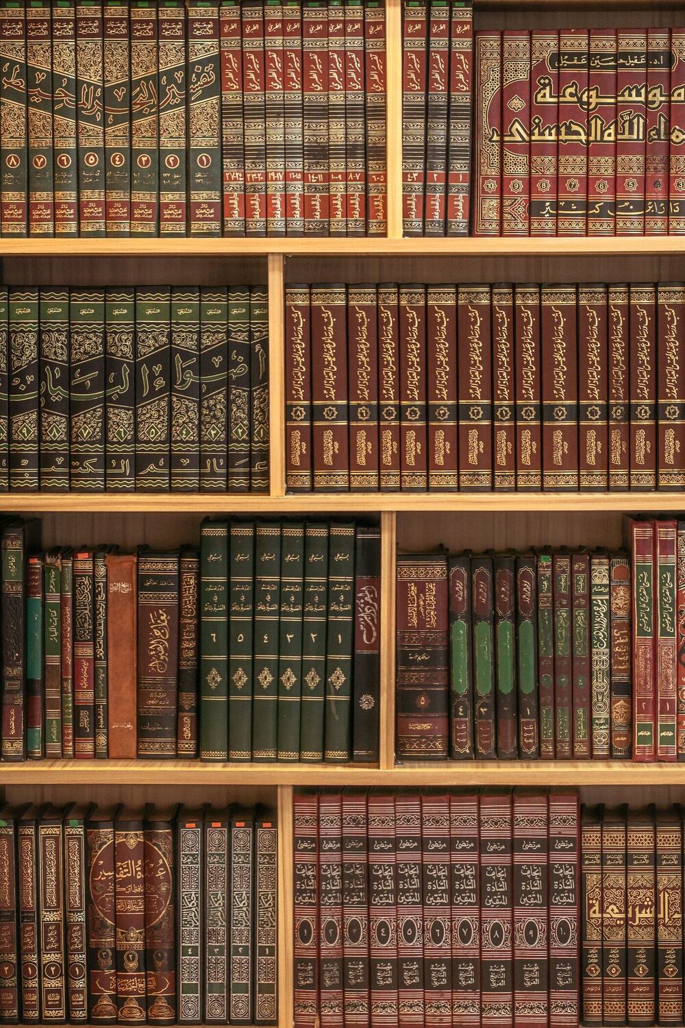 Shelves of vintage leather-bound books with gilt spines.